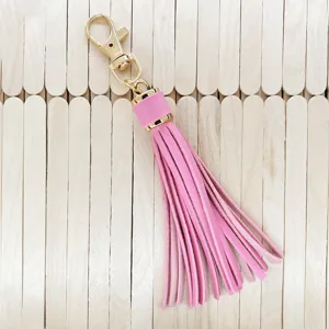 Pink PU leather tassel keychain detail showing the smooth texture, gold hardware and fringe design.