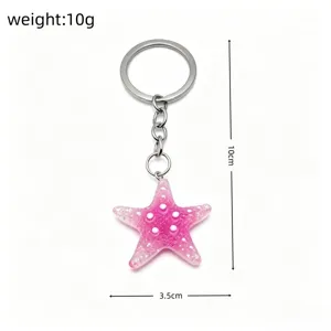Pink glitter starfish keychain detail view, featuring sparkling resin star and durable metal ring.