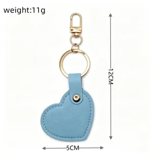 Detail view of minimalist blue heart leather keychain with gold hardware, lightweight bag charm.