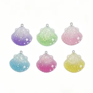 Detailed close-up of colorful gradient resin shell charms with glitter for DIY crafts.