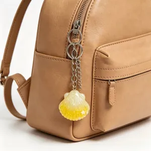 Cute simulation seashell conch keychain detail shot, perfect backpack charm and beach style accessory.