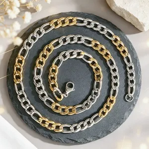 Collier maille Figaro bicolore en acier inoxydable or et argent sur socle pierre.
