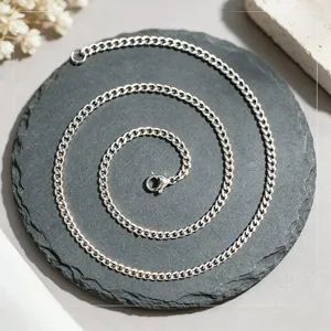 Vue détaillée d'un collier à maillons en acier inoxydable argenté disposé en spirale élégante