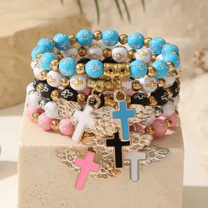 Vista detallada de pulseras de cuentas de colores con cruces y alas de ángel talladas