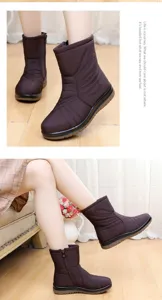 Close-up detail of women's waterproof purple snow boots with warm lining and side zipper