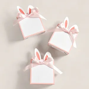 Kreative Geschenkboxen mit Hasenohren und rosa Seidenschleifen für Ostern Süßigkeiten