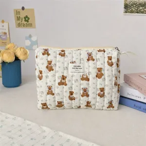 Détail d'une trousse à maquillage matelassée avec motif ours et fleurs mignon