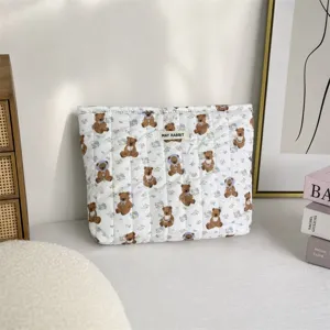 Détail d'une trousse de maquillage matelassée à motif d'ours dans un décor chaleureux