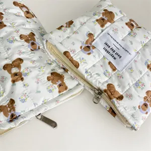 Gros plan d'une trousse de maquillage matelassée avec motif ours et étiquette