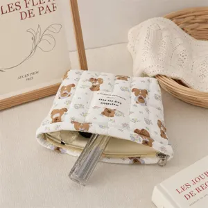 Gros plan d'une trousse de maquillage matelassée à motif d'ours avec détails de fermeture