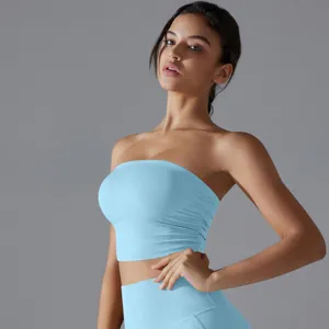 A close-up detail shot of a light blue ruched strapless yoga tube top worn by a model