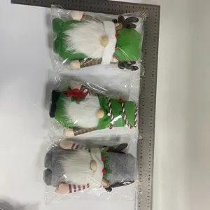 Vista detallada de tres gnomos de Navidad de felpa en bolsas individuales con una regla graduada