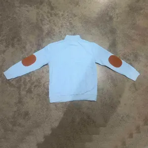 Vista posteriore di una felpa jacquard azzurra con toppe marroni sui gomiti