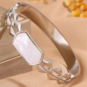 Detailed close-up of a silver stainless steel bangle featuring a white shell inlay design