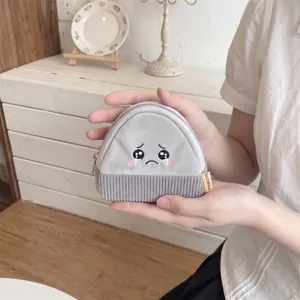 Close-up of a cute Japanese style coin purse with crying face embroidery and corduroy base