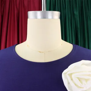 Close-up detail of navy blue dress neckline with white floral accent on mannequin