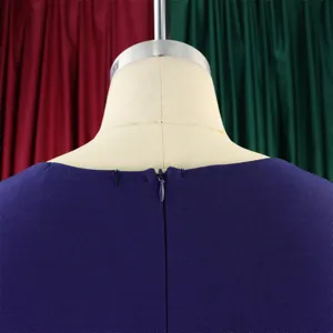 Close-up detail of hidden zipper and purple fabric texture on women's dress back.