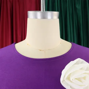 Detailed view of a purple crew neck dress featuring a large white fabric flower accessory.