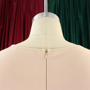 Close-up of the invisible back zipper and neckline on a slim fit apricot midi dress.