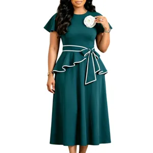 Detail view of dark green African style midi dress with white flower and ruffle waist