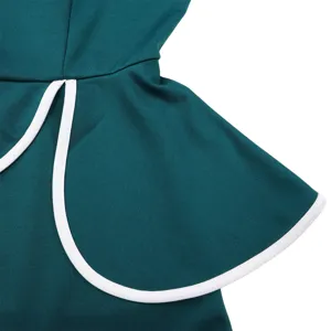 Macro detail shot of a teal summer dress featuring a ruffle with white contrast piping