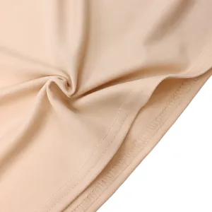 Macro view of high-quality stitching detail and soft fabric texture on a peach dress hemline.