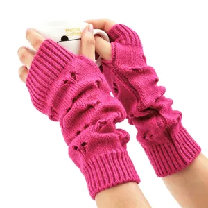 Gros plan de mitaines en tricot rose vif avec motif ajouré décontracté.