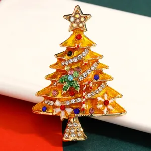 Detailansicht einer goldenen Weihnachtsbaumbrosche mit bunten Strasssteinen und Emaille