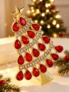 Detaillierte Ansicht einer goldenen Weihnachtsbaum-Brosche mit roten Kristallen.
