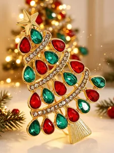 Detailansicht einer luxuriösen goldenen Weihnachtsbaumbrosche mit roten und grünen Steinen