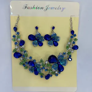 Vista dettagliata del set di gioielli vintage con fiori blu, farfalle e strass lucenti