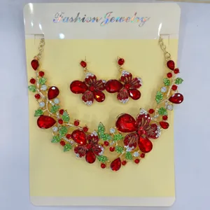 Vista dettagliata del set di gioielli collana e orecchini con farfalla e fiori rossi