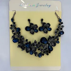 Vista dettagliata di un set di gioielli vintage in metallo nero con fiori blu