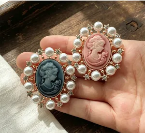Gros plan de broches camée de style victorien vintage élégantes avec des perles.