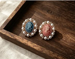 Gros plan de broches camée vintage de style victorien avec bordure en perles et strass
