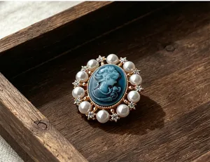 Gros plan d'une broche camée vintage victorienne avec perles sur plateau en bois