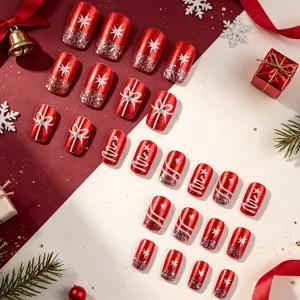 Macro view of glossy red Christmas press-on nails with silver snowflake and star designs
