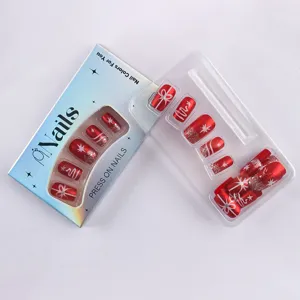 Close-up of red Christmas press-on nails with snowflake and glitter designs.