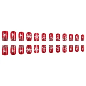 Detailed view of 24pcs red Christmas press-on nails with snowflake and glitter designs.