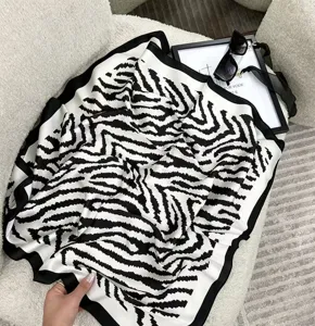 Dettaglio del foulard quadrato in seta con motivo zebrato bianco e nero elegante