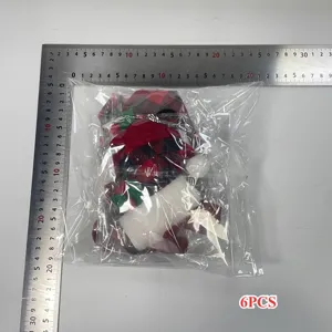 Sechs Mini-Weihnachtsmützen und -Schals in Plastikverpackung mit Messlineal daneben
