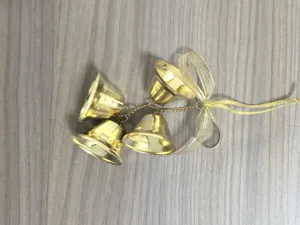 Detailed close-up view of four golden metal trumpet bells with a sheer gold ribbon bow