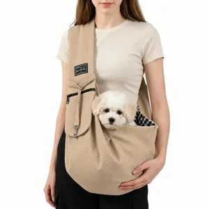 Detalle de una bolsa bandolera beige para mascotas con un perro blanco pequeño.