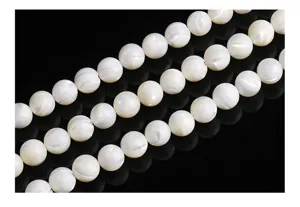 Close-up detail of iridescent white Trochus shell round beads for jewelry making