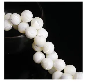 Close-up of white round shell beads with natural pearlescent luster for DIY jewelry