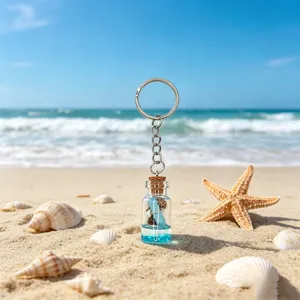 Ocean theme wishing bottle keychain featuring blue liquid and cute seashell for bag charm.
