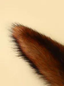 Close-up detail of fluffy faux fox fur tail pendant, soft plush texture for bag.
