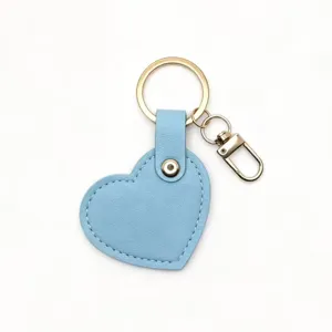 Blue heart leather keychain detail, cute bag charm, gold metal hardware keyring close-up.