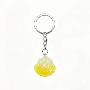 Closeup of the glitter shell pendant detail on the keychain, showing fine texture and shiny finish.