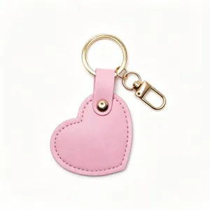 Pink heart leather keychain bag charm, detailed close-up of gold metal ring and hardware.